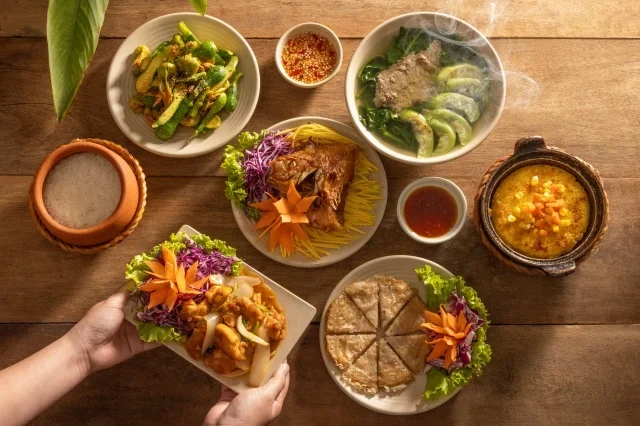 Một niêu cơm cháy vàng giòn, khói nghi ngút, bên cạnh là dĩa cá kho tộ đậm đà, nước màu óng ánh, rắc thêm tiêu xanh và ớt đỏ tạo điểm nhấn hấp dẫn.